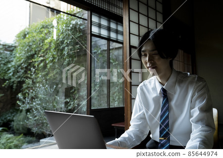 A man doing remote work in a Japanese-style room 85644974