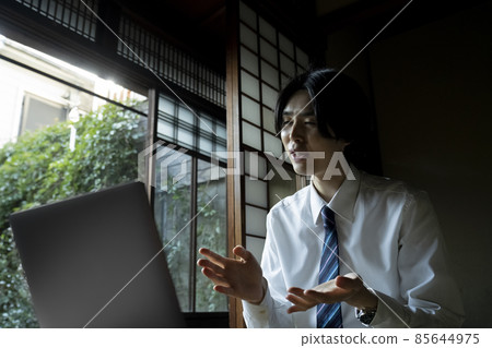 在日式房間裡做遠程工作的男人 85644975