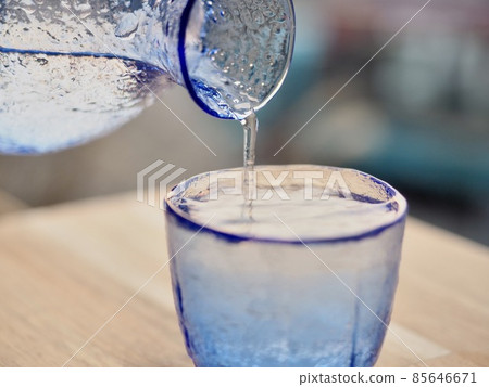 Sake blue glass sake bottle beautiful sunset back Sake blue glass sake bottle beautiful sunset back 85646671