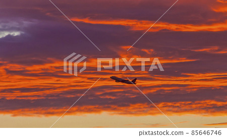 Plane in front of red glowing clouds in the evening red Plane in front of red glowing clouds in the evening red 85646746