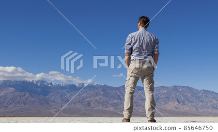 Man looks at distant mountain massif Man looks at distant mountain massif 85646750