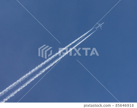 Airplane with condensation trail in blue sky 85646918