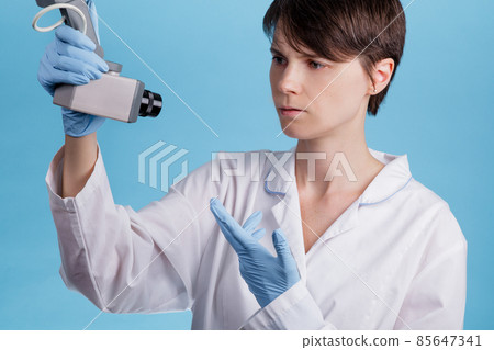 portrait of a young Caucasian female doctor looking at CCTV camera as an idea of monitoring doctors at work portrait of a young Caucasian female doctor looking at CCTV camera as an idea of monitoring doctors at work 85647341