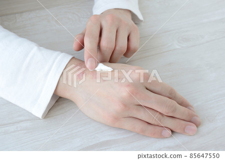 A woman's hand that applies cream to rough and rough hands 85647550