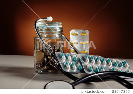 Health insurance, coin money jar with stethoscope and pills Health insurance, coin money jar with stethoscope and pills 85647803