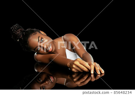 Adorable young african woman with well-kept skin isolated over dark studio background. Natural beauty concept. Adorable young african woman with well-kept skin isolated over dark studio background. Natural beauty concept. 85648234