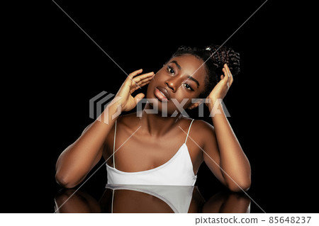 Portrait of young beautiful dark skinned woman without makeup isolated over dark studio background. Natural beauty concept. 85648237