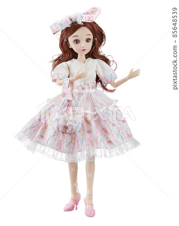 Doll is a girl of Asian appearance, in a smart pink dress, with a bow in her long brown hair, standing in pink shoes, isolated on a white background. Doll is a girl of Asian appearance, in a smart pink dress, with a bow in her long brown hair, standing in pink shoes, isolated on a white background. 85648539