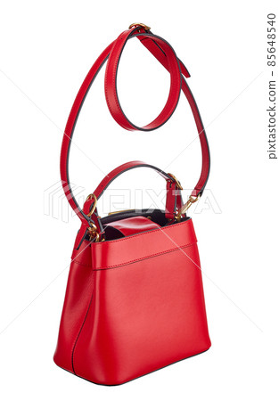 Handbag made of red leather, medium size, on a long leather strap, isolated on a white background. Expensive women's accessories. Handbag made of red leather, medium size, on a long leather strap, isolated on a white background. Expensive women's accessories. 85648540