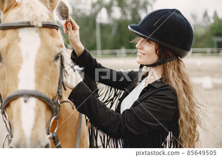 Portrait of riding horse with woman in black helmet with comb 85649505