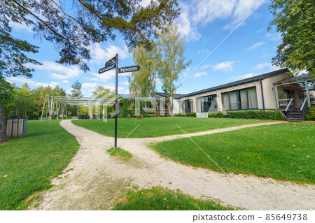 Outdoor hotel area with garden and navigational arrows 85649738