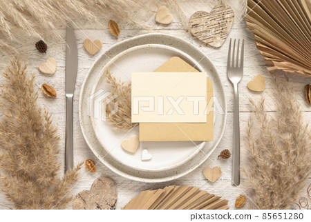 Wedding table place with blank card and envelope near dried plants and hearts, mockup Wedding table place with blank card and envelope near dried plants and hearts, mockup 85651280