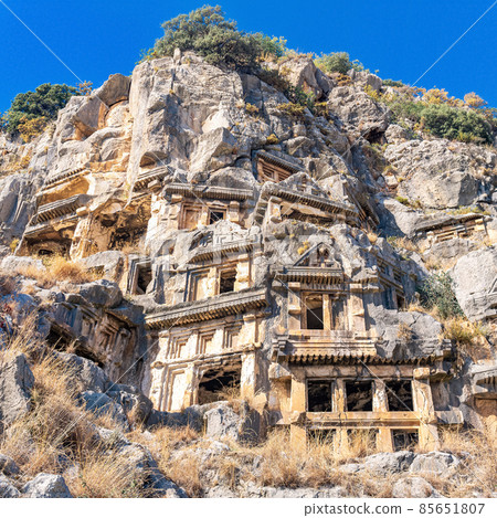 ruins of a rocky necropolis with tombs carved in stone in Myra Lycian ruins of a rocky necropolis with tombs carved in stone in Myra Lycian 85651807