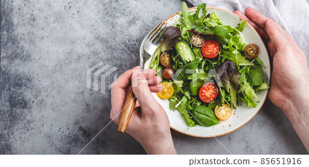 Man eating vegetarian vegetables healthy salad with red and yellow cherry tomatoes 85651916