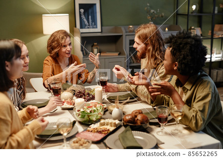 Friends talking at dining table at home Friends talking at dining table at home 85652265