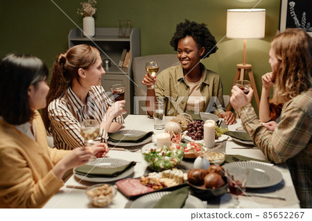 Friends sitting at dining table Friends sitting at dining table 85652267