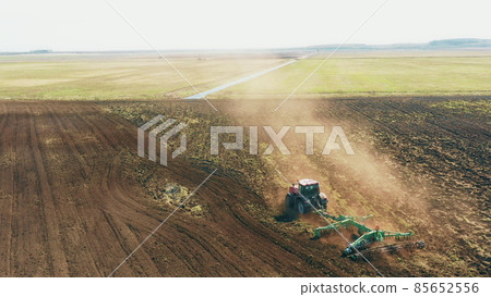 4K Aerial Elevated View.Tractor Plowing Field. Beginning Of Agricultural Spring Season. Cultivator Pulled By A Tractor In Countryside Rural Field Landscape 4K Aerial Elevated View.Tractor Plowing Field. Beginning Of Agricultural Spring Season. Cultivator Pulled By A Tractor In Countryside Rural Field Landscape 85652556