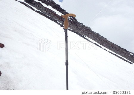 Snowy mountain climbing image: steep slope of snowy mountain and trekking pole (stock) 85653381