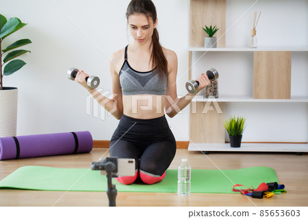 Sporty young woman doing exercising with dumbbells Sporty young woman doing exercising with dumbbells 85653603