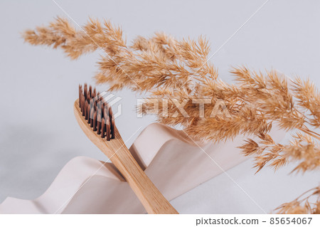Natural bamboo toothbrush on biege plaster mold against gray background with copyspace. Sustainable lifestyle, zero waste home. Selective focus Natural bamboo toothbrush on biege plaster mold against gray background with copyspace. Sustainable lifestyle, zero waste home. Selective focus 85654067