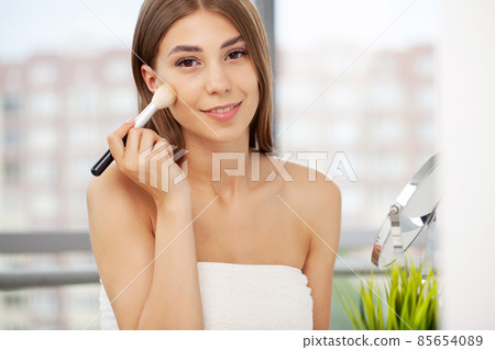 Young beautiful woman making make-up near mirror 85654089
