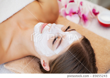Attractive funny woman with a clay spa mask on her face. Attractive funny woman with a clay spa mask on her face. 85655243