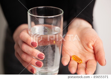 Conceptual photo of a female nutritionist holding a pill. 85655371