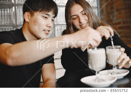 Young couple looking on a cups of cappuccino in a restaurant 85655752
