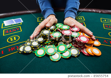 Poker player going all-in pushing his chips forward 85655754