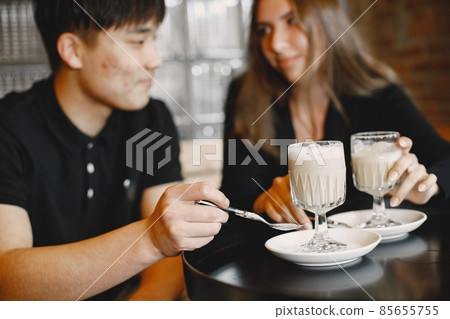 Young couple holding a cups of cappuccino in a restaurant Young couple holding a cups of cappuccino in a restaurant 85655755