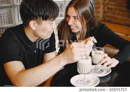 Young couple holding a cups of cappuccino in a restaurant Young couple holding a cups of cappuccino in a restaurant 85655757