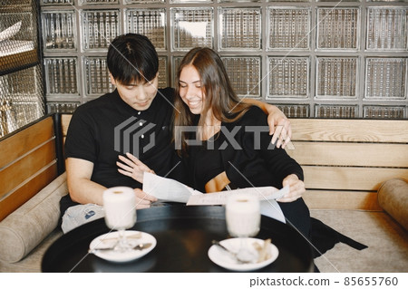 Young couple looking in menu to order dinner in restaurant Young couple looking in menu to order dinner in restaurant 85655760