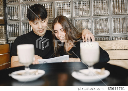 Young couple looking in menu to order dinner in restaurant Young couple looking in menu to order dinner in restaurant 85655761