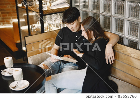 Young couple looking in menu to order dinner in restaurant Young couple looking in menu to order dinner in restaurant 85655766
