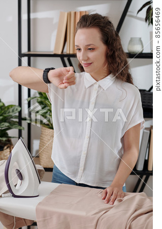 Ironing Woman Checking Smartwatch Ironing Woman Checking Smartwatch 85656469