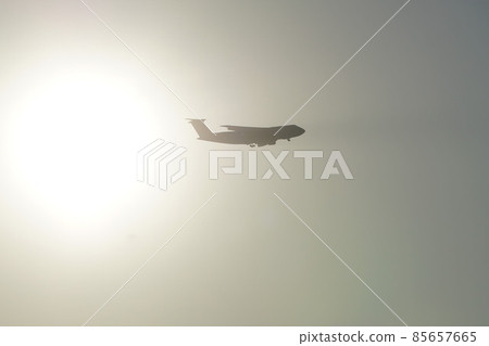 Galaxy transport plane crossing the setting sun and getting ready for landing Galaxy transport plane crossing the setting sun and getting ready for landing 85657665