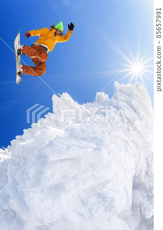 Snowboarder jumping against blue sky in high mountains 85657991