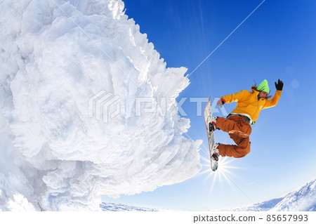 Snowboarder jumping against blue sky in high mountains 85657993