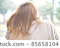 A woman walking with a yellow umbrella in the snow 85658104