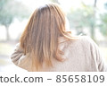 A woman walking with a yellow umbrella in the snow 85658109
