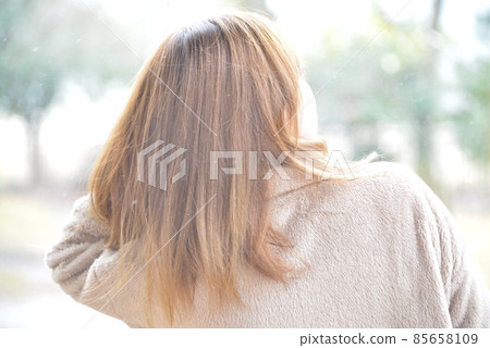 A woman walking with a yellow umbrella in the snow 85658109