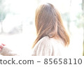 A woman walking with a yellow umbrella in the snow 85658110