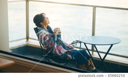 A woman drinking coffee gracefully on the veranda A woman drinking coffee gracefully on the veranda 85660250