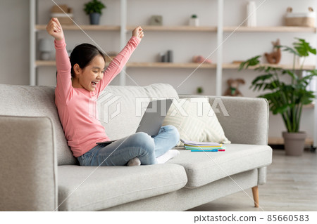 Emotional asian schooler celebrating success, home interior Emotional asian schooler celebrating success, home interior 85660583