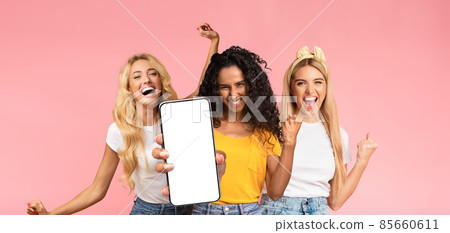 Carefree millennial ladies having fun, showing smartphone, mockup Carefree millennial ladies having fun, showing smartphone, mockup 85660611