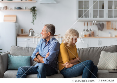 Unhappy Senior Spouses Sitting On Couch Back-To-Back After Quarrel Indoor Unhappy Senior Spouses Sitting On Couch Back-To-Back After Quarrel Indoor 85660686
