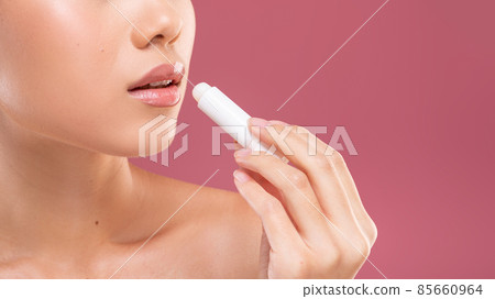 Unrecognizable woman showing her balm for lips 85660964