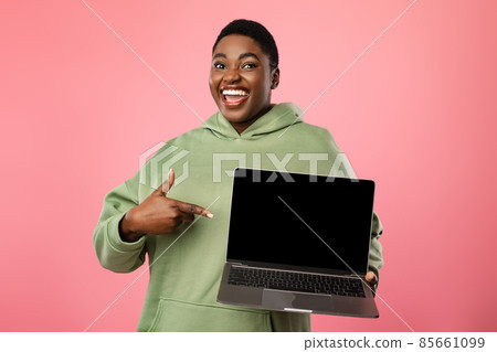 African Woman Pointing Finger At Laptop Empty Screen, Pink Background 85661099