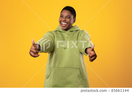 African American Female Gesturing Thumbs-Up With Both Hands, Yellow Background 85661144
