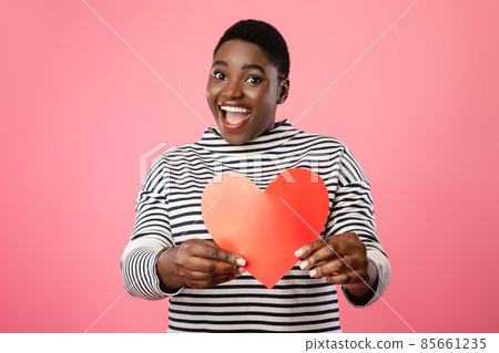 Cheerful Overweight Black Lady Showing Red Paper Heart, Pink Background Cheerful Overweight Black Lady Showing Red Paper Heart, Pink Background 85661235